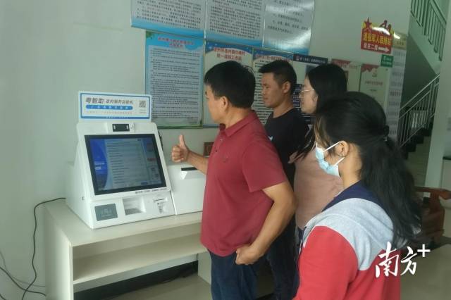 村民老張豎起大拇指點贊“粵智助”政府服務自助機。通訊員供圖