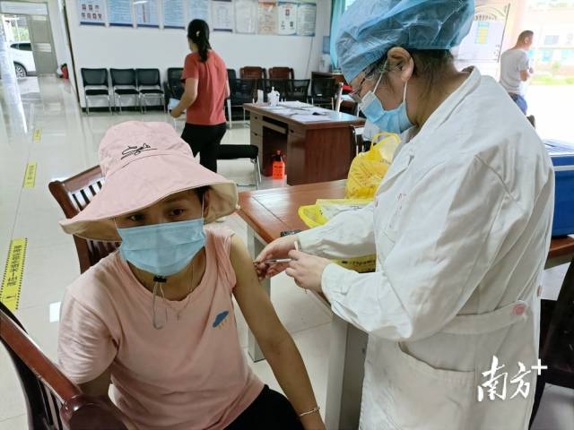 醫(yī)護人員為村民接種疫苗。