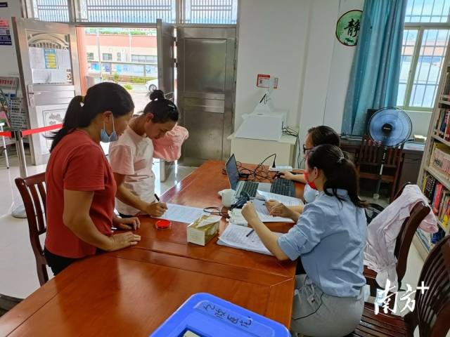 鎮(zhèn)、村干部為村民進行接種信息錄入。