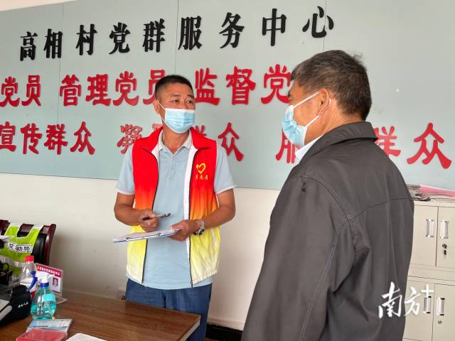 正在為群眾辦事的沈家江（左）。